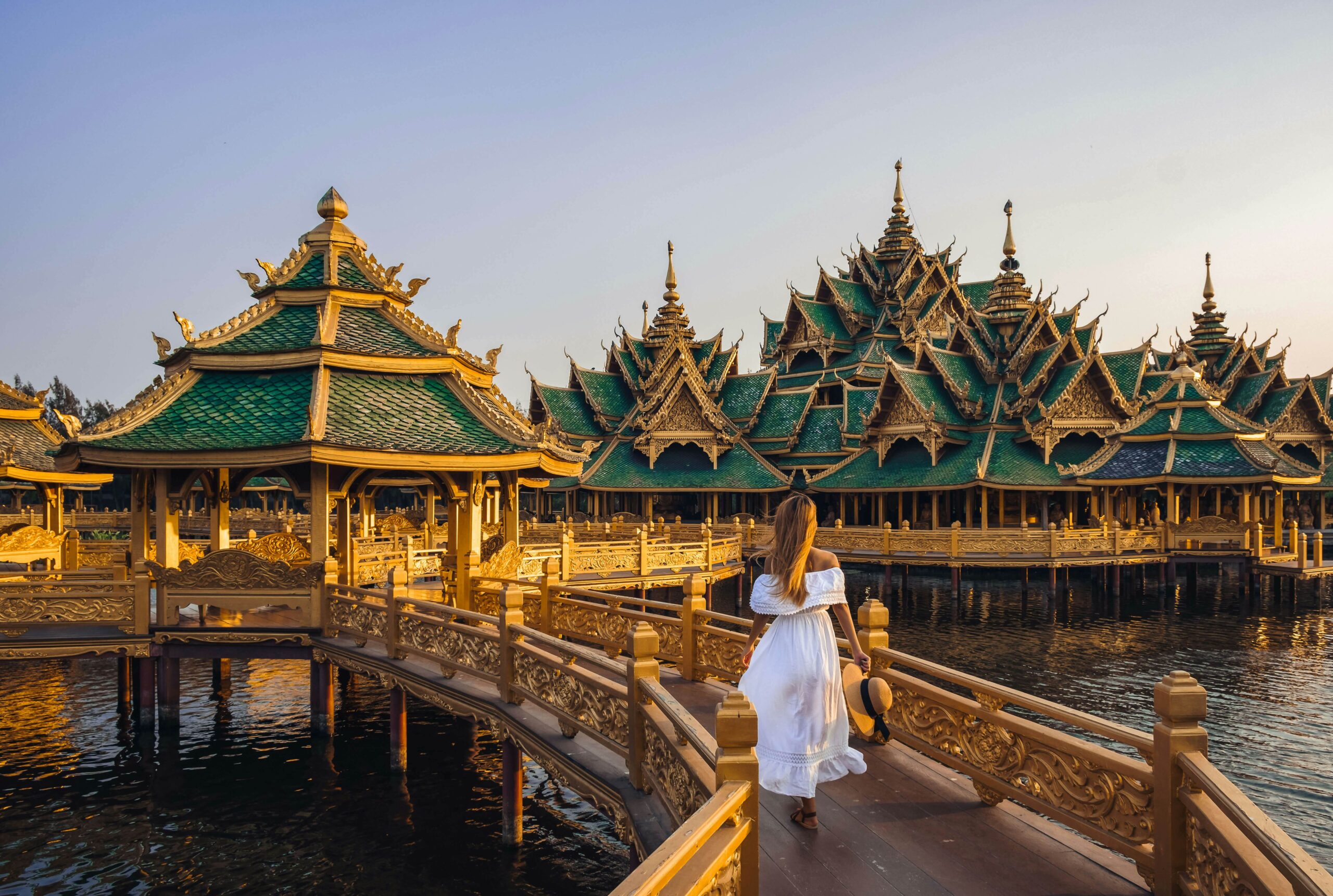 Woman walking on a bridge to Buddhist templae in Thailand during sunset Kiszon Pascal GettyImages 1135361816 rfc scaled